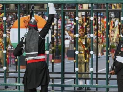 Pakistan's Rangers soldier, in black, and Indian Border Security Forces soldier, gesture to each other during a daily closing ceremony at the Wagah, a joint post on the Pakistan and India border, near Lahore, Pakistan, Saturday, May 3, 2025. (AP Photo/K.M. Chaudary)