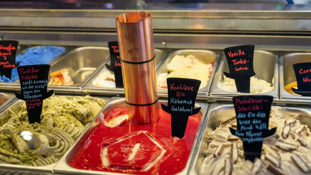 07 May 2025, Bavaria, Munich: In the Munich ice cream parlor "Der verrückte Eismacher - im Wunderland", the ice cream counter features the "Conclave ice cream" variety with a small chimney with incense and a tiara, the well-known papal headdress, painted into the ice cream. Photo: Leonie Asendorpf/dpa,Image: 996185861, License: Rights-managed, Restrictions: GERMANY OUT, Model Release: no