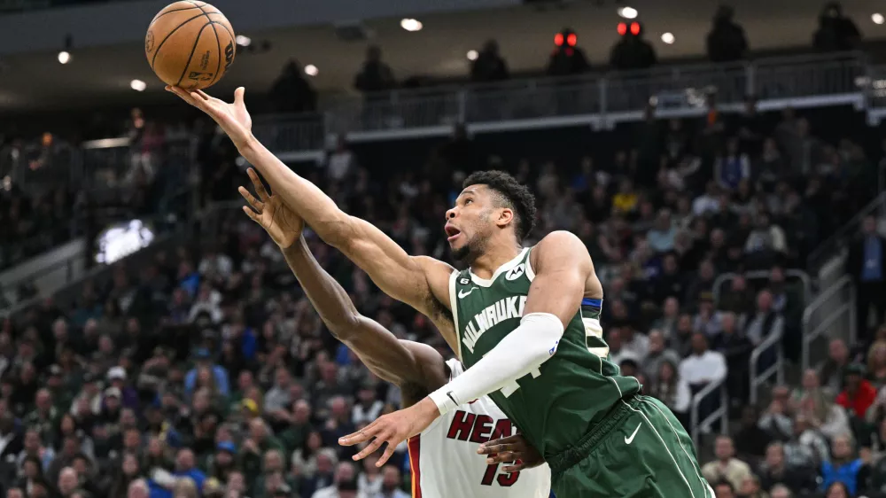 Apr 26, 2023; Milwaukee, Wisconsin, USA; Milwaukee Bucks forward Giannis Antetokounmpo (34) lays up a shot against Miami Heat center Bam Adebayo (13) during game five of the 2023 NBA Playoffs at Fiserv Forum. Mandatory Credit: Michael McLoone-USA TODAY Sports