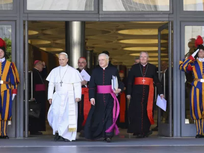 Pope Leo XIV, left, is flanked by Monsignor Leonardo Sapienza, second from left, after his meeting with the College of Cardinals in the New Synod Hall at the Vatican, Saturday, May 10, 2025. (Vatican Media via AP)