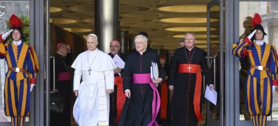 Pope Leo XIV, left, is flanked by Monsignor Leonardo Sapienza, second from left, after his meeting with the College of Cardinals in the New Synod Hall at the Vatican, Saturday, May 10, 2025. (Vatican Media via AP)