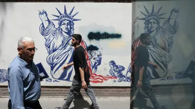 People walk past an anti-U.S. mural on a street in Tehran, Iran, May 11, 2025. Majid Asgaripour/WANA (West Asia News Agency) via REUTERS  ATTENTION EDITORS - THIS PICTURE WAS PROVIDED BY A THIRD PARTY