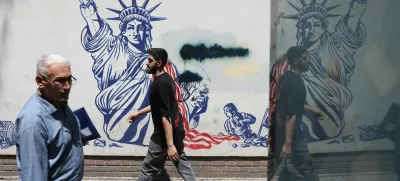 People walk past an anti-U.S. mural on a street in Tehran, Iran, May 11, 2025. Majid Asgaripour/WANA (West Asia News Agency) via REUTERS  ATTENTION EDITORS - THIS PICTURE WAS PROVIDED BY A THIRD PARTY