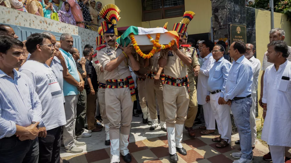 Policemen carry the body of Raj Kumar Thapa, a senior government official who was killed in a cross-border shelling between India and Pakistan, as relatives and neighbours mourn during his funeral in Roop Nagar, Jammu May 11, 2025. REUTERS/Adnan Abidi