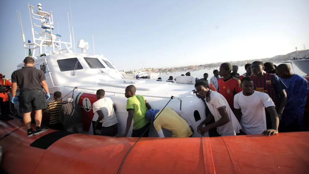 ﻿Migrants prepare to disembark in the island of Lampedusa, Italy, Wednesday, Aug. 7, 2013, after being rescued at sea by the Italian Coast Guard. Thousands of migrants heading to Europe arrive in Malta and Italy each year, often aboard unseaworthy boats. The Italian government has agreed to accept 102 migrants rescued at sea by a tanker that has been denied entry to Malta for two days. (AP Photo/Francesco Malavolta)