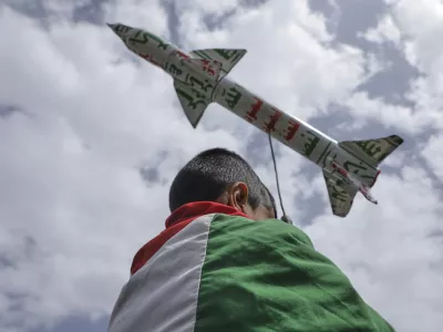 A boy draped in a Palestinian flag carries a mock rocket during a weekly anti-U.S. and anti-Israel rally organized by Houthi supporters in Sanaa, Yemen, Friday, May 9, 2025. (AP Photo/Osamah Abdulrahman)