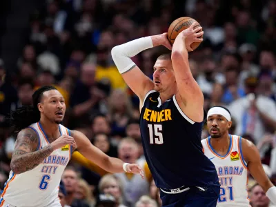 Denver Nuggets center Nikola Jokic, center, looks to pass the ball as Oklahoma City Thunder forward Jaylin Williams, left, and guard Aaron Wiggins defend in the second half of Game 4 in the Western Conference semifinals of the NBA basketball playoffs Sunday, May 11, 2025, in Denver. (AP Photo/David Zalubowski)