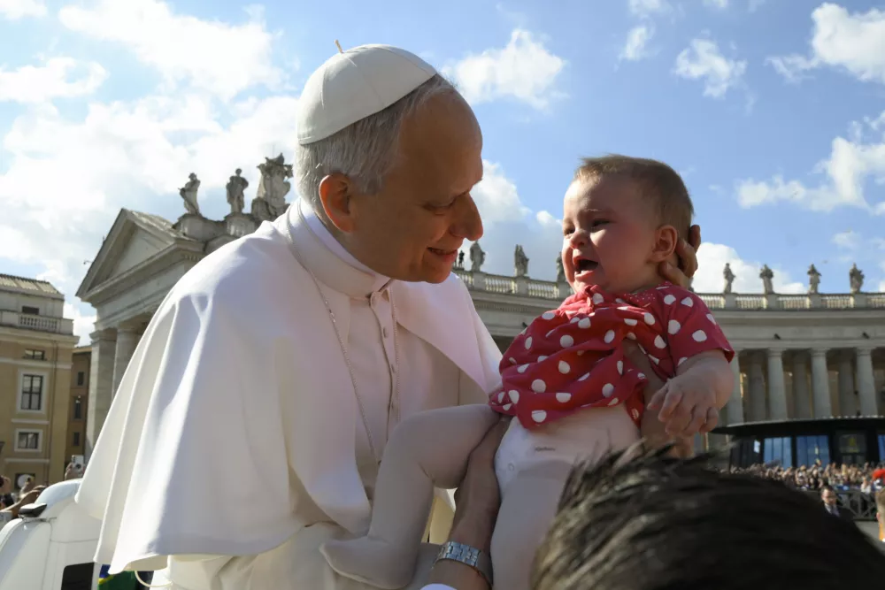 18 May 2025, Vatican, Vatican City: Pope Leo XIV holds a child during the ceremonial opening of his pontificate in St. Peter's Square at the Vatican. Photo: -/Vatican Media via IPA via ZUMA Press/dpa / Foto: -