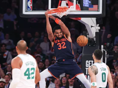 May 12, 2025; New York, New York, USA; New York Knicks center Karl-Anthony Towns (32) dunks the ball in the second half during game four of the second round for the 2025 NBA Playoffs in front of Boston Celtics forward Jayson Tatum (0) at Madison Square Garden. Mandatory Credit: Vincent Carchietta-Imagn Images