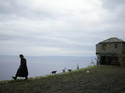 Father Paisios is followed by cats walks at the Simonopetra, or Simonos Petra Monastery, home of the all-male autonomous community of Agion Oros, or Holy Mountain, on the peninsula of Mount Athos in northern Greece, Monday, April 14, 2025. (AP Photo/Thanassis Stavrakis)
