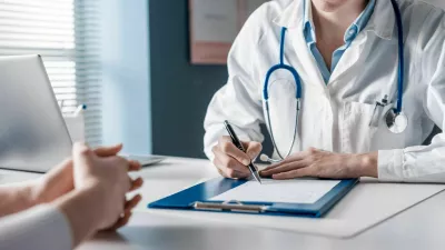 Doctor sitting at desk and writing a prescription for her patient / Foto: Demaerre