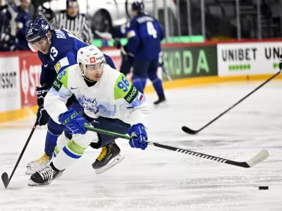 Finland's Mikael Ruohomaa, left, and Slovenia's Bine Masic, right, challenge for the puck during the IIHF Ice Hockey World Championship group A match between Finland and Slovenia in Stockholm, Sweden, Thursday, May 15, 2025. (Anders Wiklund/TT News Agency via AP)