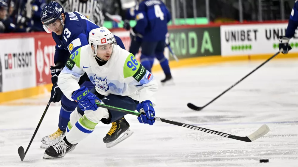 Finland's Mikael Ruohomaa, left, and Slovenia's Bine Masic, right, challenge for the puck during the IIHF Ice Hockey World Championship group A match between Finland and Slovenia in Stockholm, Sweden, Thursday, May 15, 2025. (Anders Wiklund/TT News Agency via AP)