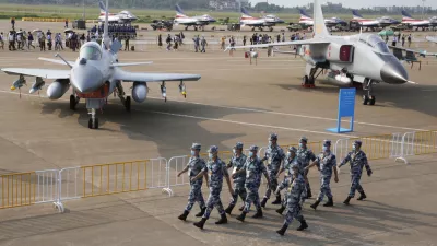 ﻿Chinese Air Force personnel march past the Chinese military's J10C fighter and JH-7A2 fighter bomber during 13th China International Aviation and Aerospace Exhibition, also known as Airshow China 2021, Wednesday, Sept. 29, 2021, in Zhuhai in southern China's Guangdong province. With record numbers of military flights near Taiwan over the last week, China has been stepping up its harassment of the island it claims as its own, showing an new intensity and sophistication as it asserts its territorial claims in the region. (AP Photo/Ng Han Guan)