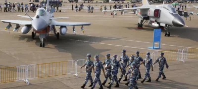 ﻿Chinese Air Force personnel march past the Chinese military's J10C fighter and JH-7A2 fighter bomber during 13th China International Aviation and Aerospace Exhibition, also known as Airshow China 2021, Wednesday, Sept. 29, 2021, in Zhuhai in southern China's Guangdong province. With record numbers of military flights near Taiwan over the last week, China has been stepping up its harassment of the island it claims as its own, showing an new intensity and sophistication as it asserts its territorial claims in the region. (AP Photo/Ng Han Guan)