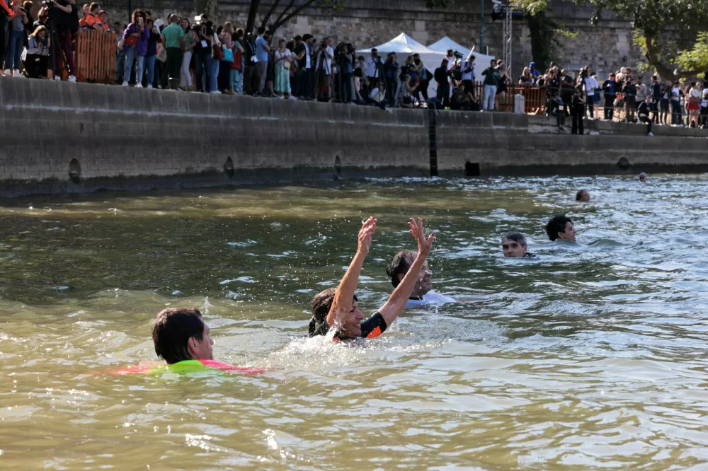 Paris Mayor Anne Hidalgo swims in the Seine, to demonstrate that the river is clean enough to host the outdoor swimming events at the Paris Olympics later this month, in Paris, France, July 17, 2024. JOEL SAGET/Pool via REUTERS