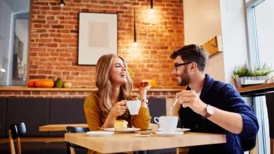 ﻿Couple of young people drinking coffee and eating cake in a stylish modern cafeteria