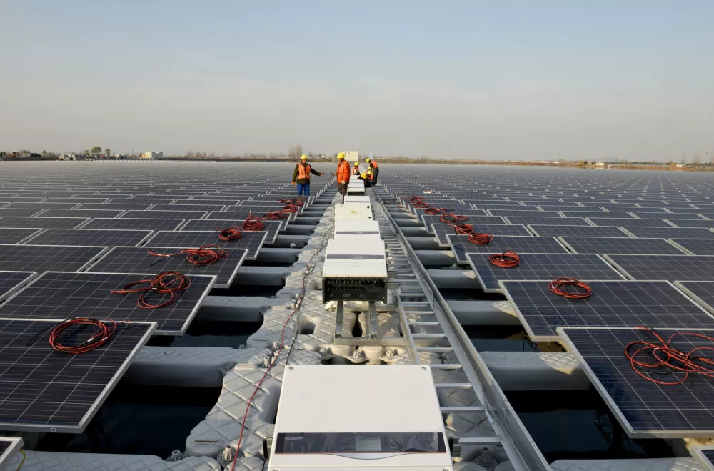 ﻿Workers install solar panels at a floating solar plant developed by China's Three Gorges Group, in Huainan, Anhui province, China December 11, 2017. Picture taken December 11, 2017. REUTERS/Stringer ATTENTION EDITORS - THIS IMAGE WAS PROVIDED BY A THIRD PARTY. CHINA OUT.