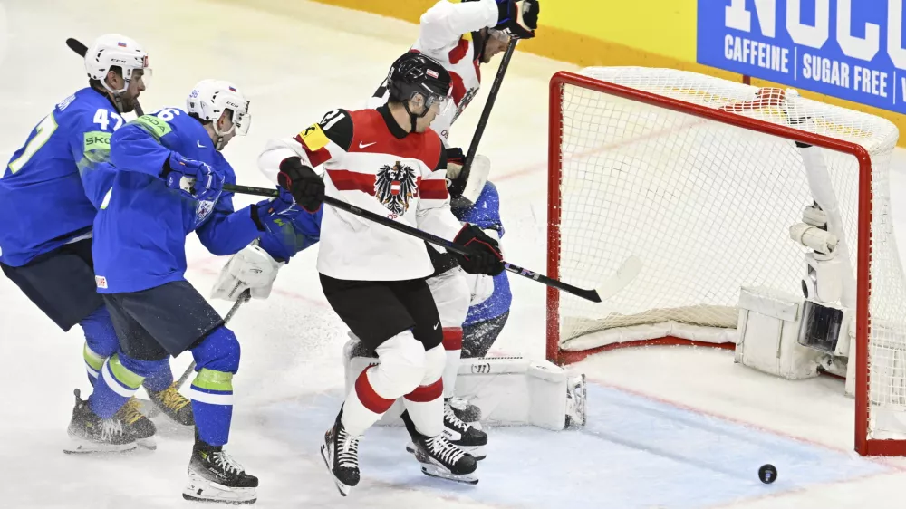 Austria's Lukas Haudum, center, in action during the IIHF Ice Hockey World Championship group A match between Slovenia and Austria at Avicii Arena in Stockholm, Sweden, Sunday May 18, 2025. (Anders Wiklund/TT News Agency via AP)