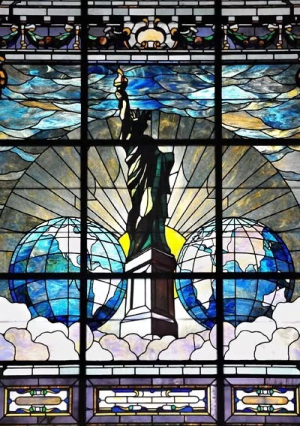 Svoboda razsvetljuje svet ali Kip svobode, vitraž, ki ga je naročil Joseph Pulitzer v spomin na zbiranje sredstev pri časopisni hiši New York World za podstavek Kipa svobode. Prvotno je bil vitraž nameščen v stavbi New York World Building, nato pa so ga prestavili v Pulitzerjevo dvorano na Univerzo Columbia. / Foto: Wikipedija