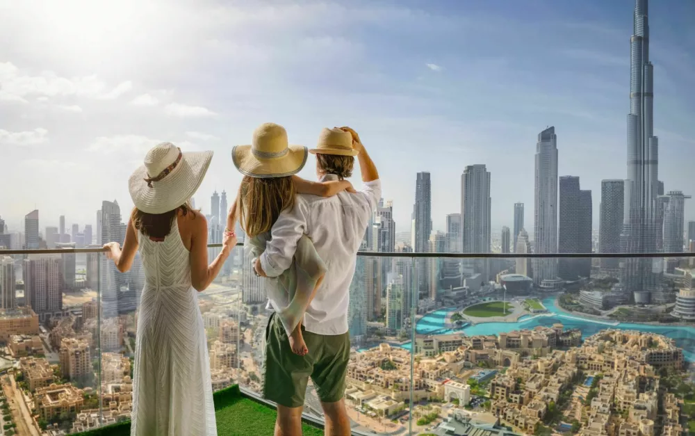 A elegant family on a city break vacation enjoys the panoramic view over the skyline of Dubai, UAE / Foto: Shansche