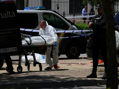 A staff of a funeral home moves the body of former Ukrainian politician Andriy Portnov on a stretcher, at the spot where, according to the Spain's Interior Ministry, he was shot and killed by unidentified gunmen, outside a school, in Madrid, Spain May 21, 2025. REUTERS/Nacho Doce
