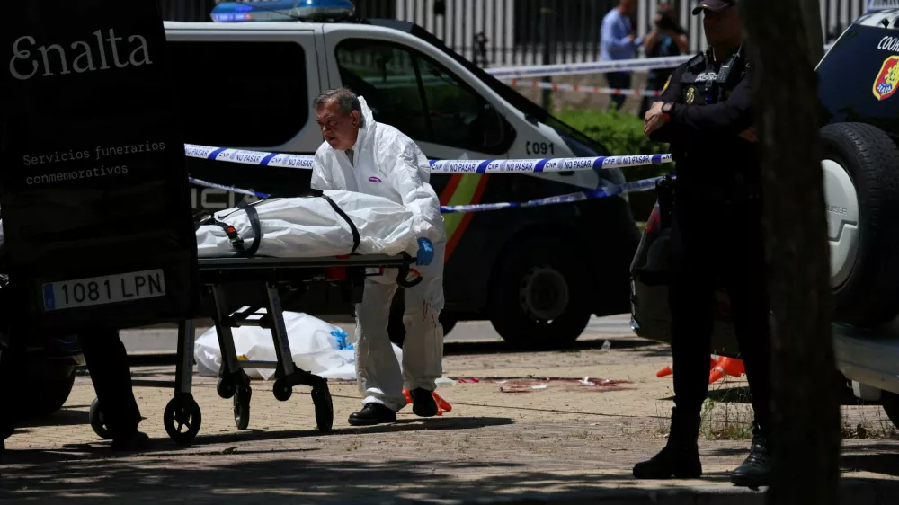 A staff of a funeral home moves the body of former Ukrainian politician Andriy Portnov on a stretcher, at the spot where, according to the Spain's Interior Ministry, he was shot and killed by unidentified gunmen, outside a school, in Madrid, Spain May 21, 2025. REUTERS/Nacho Doce