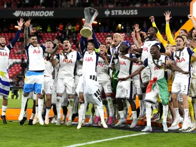 Tottenham Hotspur's Son Heung-Min lifts the trophy with teammates following the team's victory in the UEFA Europa League final against Manchester United at the Estadio de San Mames in Bilbao, Spain, Wednesday, May 21, 2025. (Nick Potts/PA via AP)