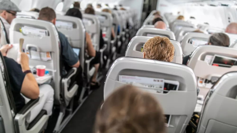 Interior of commercial airplane with passengers in their seats during flight.