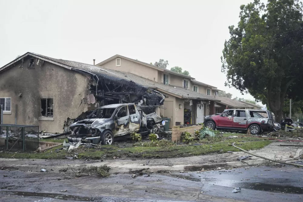 Vehicles and houses are damages after a small plane crashed into a San Diego neighborhood, setting several homes on fire and forcing evacuations along several blocks early Thursday, May 22, 2025. (AP Photo/Gregory Bull)