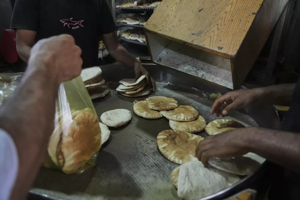 Palestinians bake bread after the World Food Program was able to bring in flour for the first time in over a month as Israel allowed some aid to enter the Gaza Strip, in Deir al-Balah, Gaza Strip, Thursday, May 22, 2025. (AP Photo/Abdel Kareem Hana)