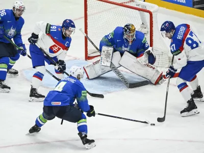 Slovenia's goalkeeper Matija Pintaric, center, and from left, Slovenia's Bine Masic, Slovakia's Matus Sukel, Slovenia's Aleksandar Magovac and Slovakia's Pavol Regenda in action, during the IIHF Ice Hockey World Championship group A match between Slovakia and Slovenia, at Avicii Arena in Stockholm, Sweden, Sunday, May 11, 2025. (Fredrik Sandberg/TT News Agency via AP)