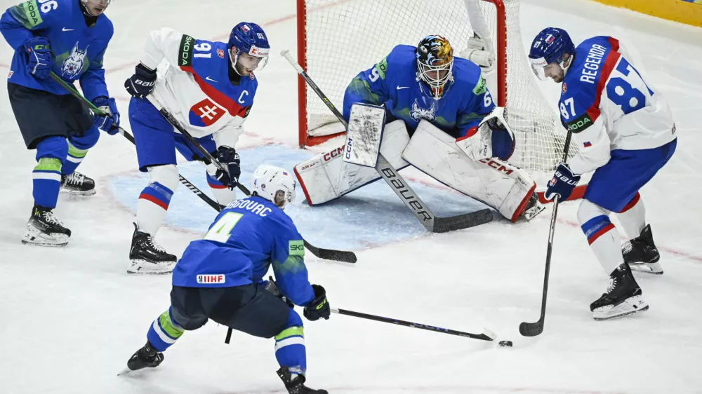 Slovenia's goalkeeper Matija Pintaric, center, and from left, Slovenia's Bine Masic, Slovakia's Matus Sukel, Slovenia's Aleksandar Magovac and Slovakia's Pavol Regenda in action, during the IIHF Ice Hockey World Championship group A match between Slovakia and Slovenia, at Avicii Arena in Stockholm, Sweden, Sunday, May 11, 2025. (Fredrik Sandberg/TT News Agency via AP)