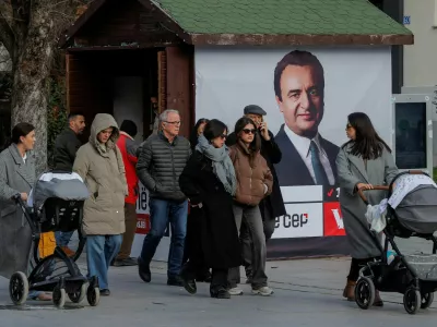 FILE PHOTO: Pedestrians walk near a campaign poster for the upcoming parliamentary elections showing a portrait of Albin Kurti, Kosovo's Prime Minister and leader of the Self-Determination party, in Pristina, Kosovo February 4, 2025. REUTERS/Valdrin Xhemaj/File Photo