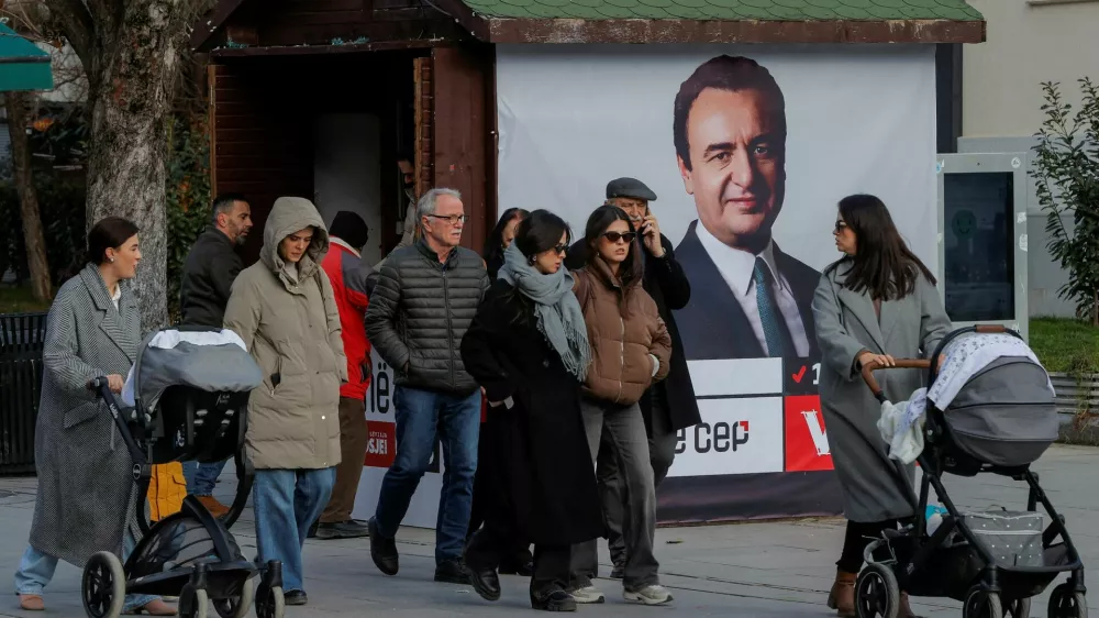 FILE PHOTO: Pedestrians walk near a campaign poster for the upcoming parliamentary elections showing a portrait of Albin Kurti, Kosovo's Prime Minister and leader of the Self-Determination party, in Pristina, Kosovo February 4, 2025. REUTERS/Valdrin Xhemaj/File Photo
