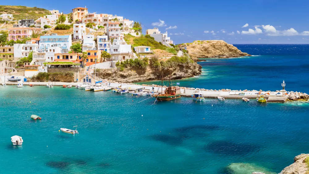 Harbour with marine vessels, boats and lighthouse. Panoramic view from a cliff on a Bay with a beach and architecture Bali - vacation destination resort, with secluded beaches and clear turquoise ocean waters, Rethymno, Crete, Greece