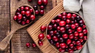 Ripe cranberry in wooden bowl on wooden table. / Foto: Gitusik