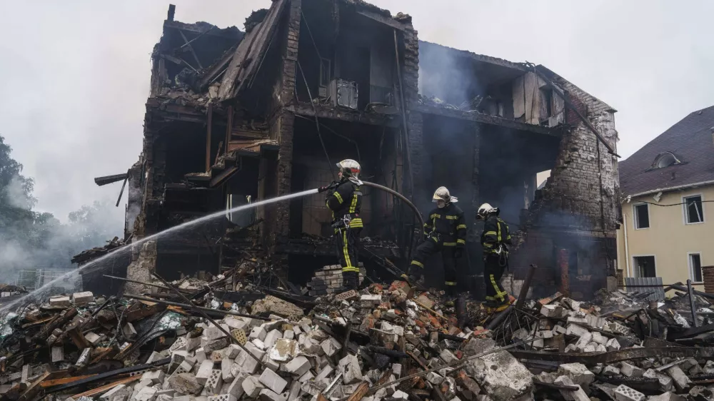 Rescue workers extinguish a fire of a house destroyed by a Russian strike in Markhalivka village, Kyiv region, Ukraine, Sunday, May 25, 2025. (AP Photo/Evgeniy Maloletka)