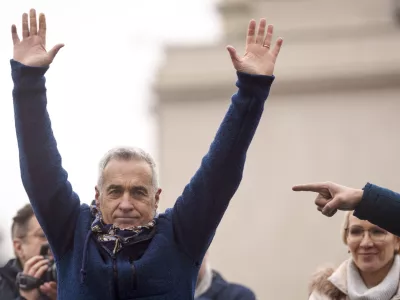 FILE - Calin Georgescu, the winner of the first round of presidential elections, later annulled by the Constitutional Court, waves to supporters during a protest, in Bucharest, Romania, March 1, 2025. (AP Photo/Vadim Ghirda, File)