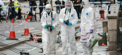 Forensic officers work near the site of an incident where a car plowed into a crowd of Liverpool fans during a parade celebrating their side's Premier League soccer title, in central Liverpool, Britain, May 27, 2025. REUTERS/Phil Noble