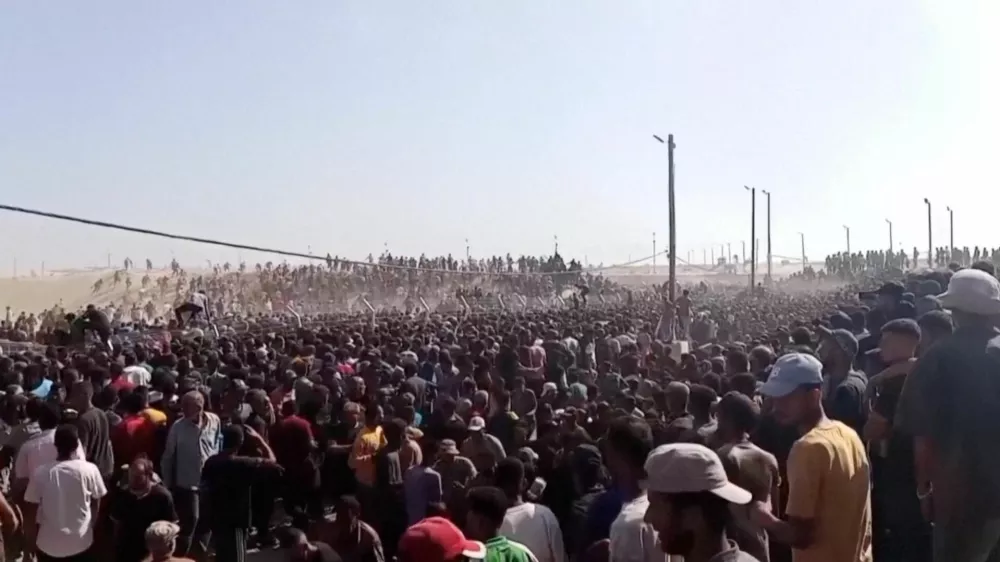 Palestinians rush to get aid boxes, in Rafah, in the southern Gaza Strip, May 27, 2025, in this screengrab from a video. Reuters TV/via REUTERS