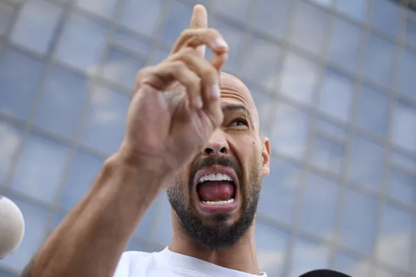 FILE - Andrew Tate speaks to media outside the Bucharest Tribunal after being placed under house arrest, in Bucharest, Romania, Aug. 22, 2024. (AP Photo/Alexandru Dobre, File)