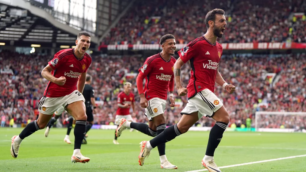26 August 2023, United Kingdom, Manchester: Manchester United's Bruno Fernandes (R) celebrates scoring his side's third goal with teammate during the English Premier League soccer match between Manchester United and Nottingham Forest at Old Trafford. Photo: Nick Potts/PA Wire/dpa
