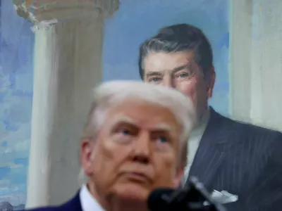 A portrait of former U.S. President Ronald Reagan hangs behind U.S. President Donald Trump as he answers questions from members of the news media in the Oval Office at the White House in Washington, D.C., U.S., May 28, 2025. REUTERS/Leah Millis