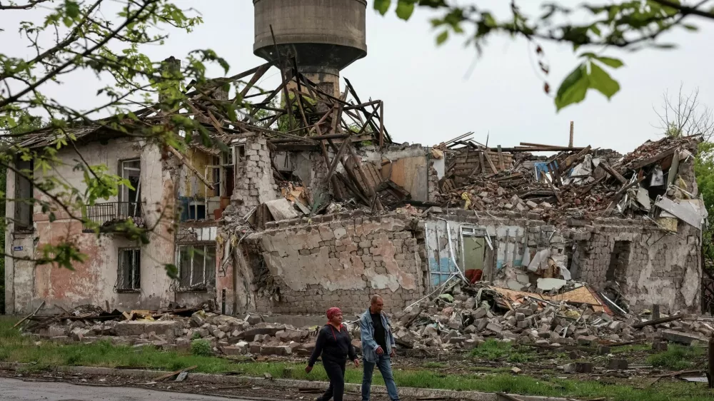 Residents walk at a street near buildings damaged by Russian military strikes, amid Russia's attack on Ukraine, in the frontline town of Myrnohrad, Donetsk region, Ukraine May 29, 2025. REUTERS/Anatolii Stepanov