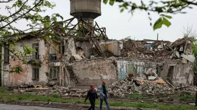Residents walk at a street near buildings damaged by Russian military strikes, amid Russia's attack on Ukraine, in the frontline town of Myrnohrad, Donetsk region, Ukraine May 29, 2025. REUTERS/Anatolii Stepanov