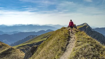 nice senior woman, hiking in fall, autumn on the ridge of the Nagelfluh chain near Oberstaufen, Allgaeu Area, Bavaria, Germany, Hochgrats summit in the background