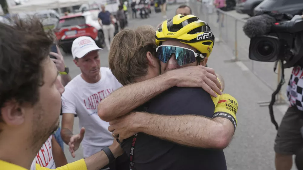 Britain's Simon Yates hugs a team' staffer after completing the stage 20 and take the lead of the Giro d'Italia cycling race, from Verres to Sestriere (Via Lattea), Italy, Saturday, May 31, 2025. (Gian Mattia D'Alberto /LaPresse via AP)