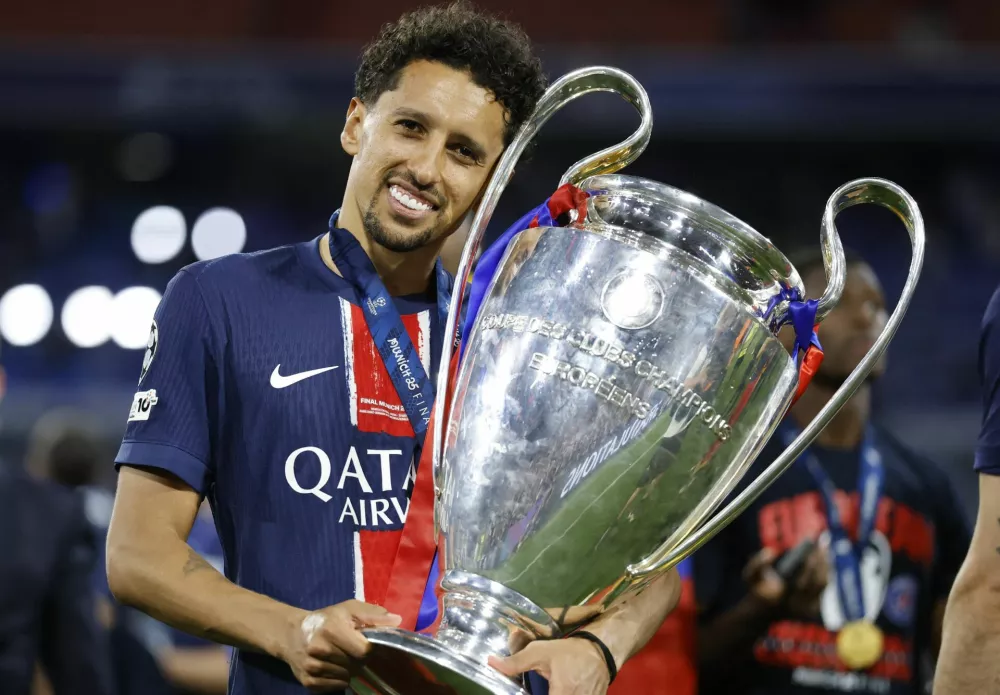 Soccer Football - Champions League - Final - Paris St Germain v Inter Milan - Allianz Arena, Munich, Germany - May 31, 2025 Paris St Germain's Marquinhos celebrates with the trophy after winning the Champions League REUTERS/Peter Cziborra