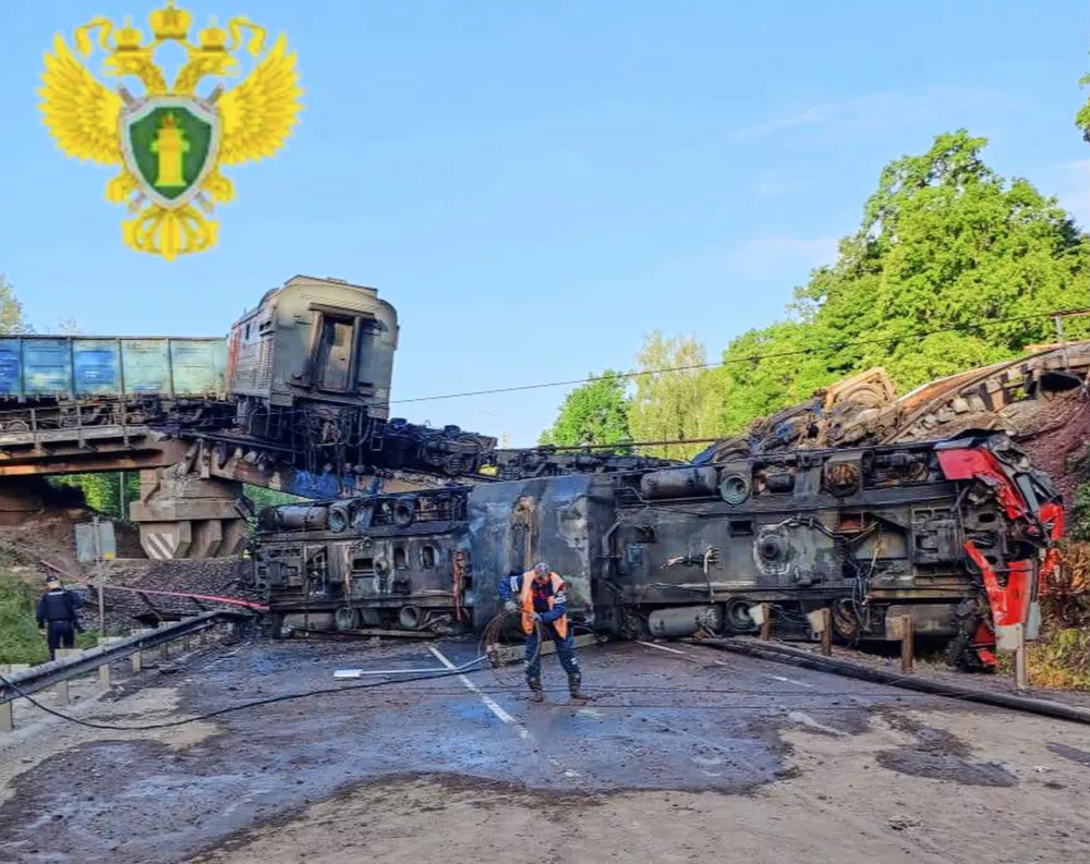 In this photo released by Moscow Interregional Transport Prosecutor's Office telegram channel on Sunday, June 1, 2025, an emergency employee works at a damaged bridge after the crash of a freight train in Russia's Kursk region, which borders Ukraine. (Moscow Interregional Transport Prosecutor's Office telegram channel via AP)